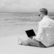 Young businessman using laptop computer on the beach